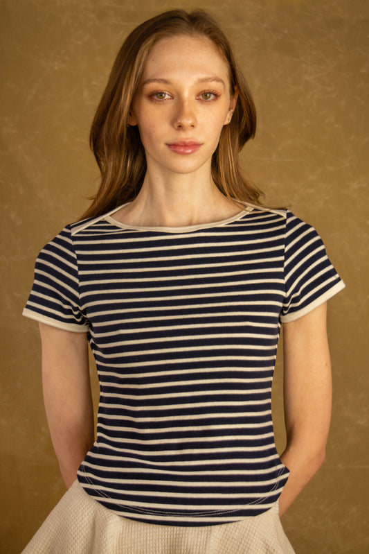 Woman wearing a navy and white striped shirt against a brown background